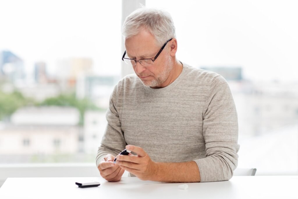 Senior man checking his blood sugar with a glucometer at home as part of daily diabetes management
